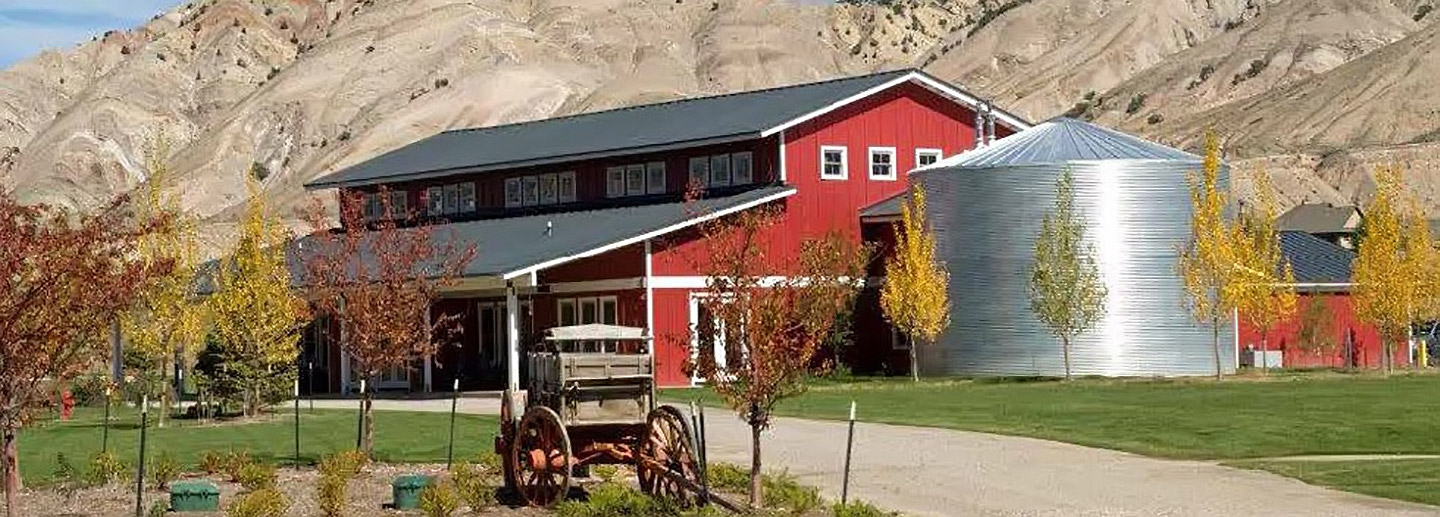 A photo of a rustic red barn illustrates the location of this Colorado summer camp