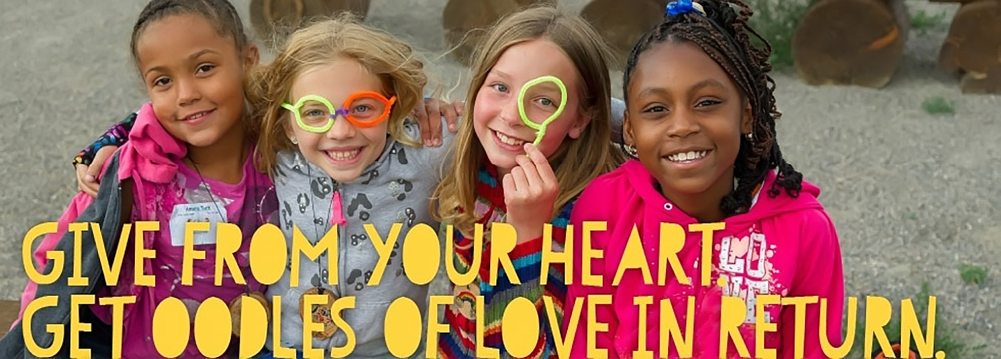 Four children smile for the camera to promote fundraising for nonprofit organization, with text reading Give From Your Heart Get Oodles of Love In Return