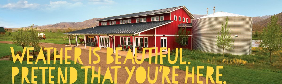 The view of a rustic barn on a sunny day at Roundup River Ranch youth camp
