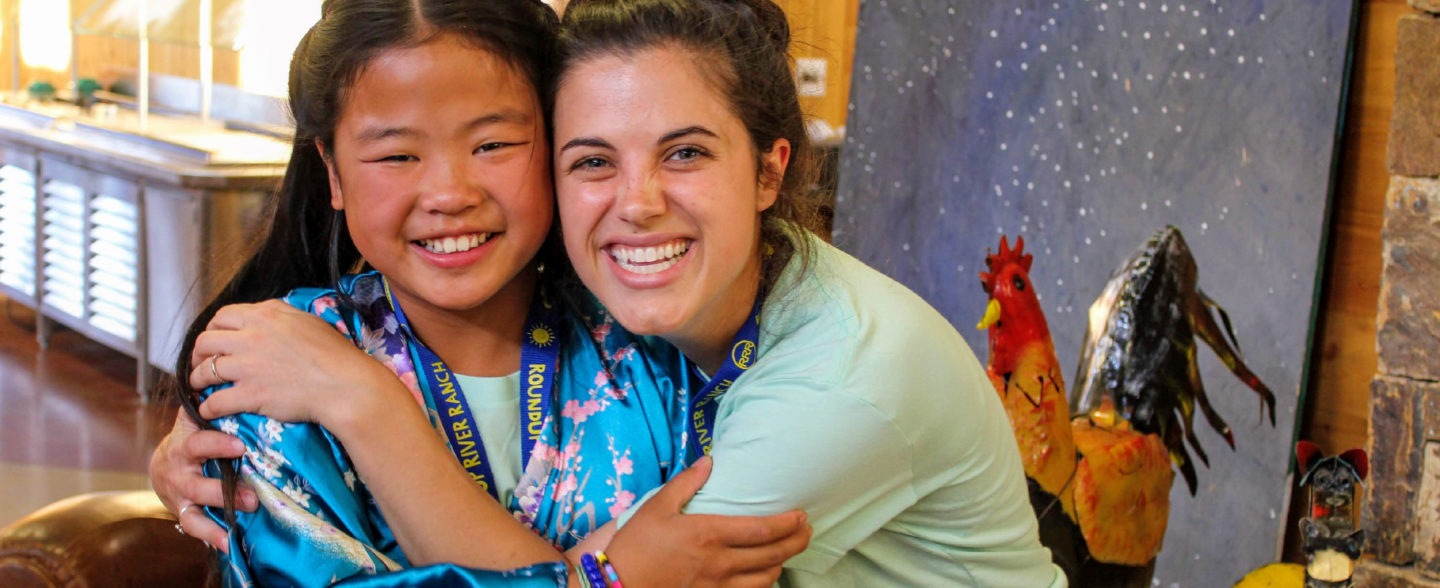 A camper and camp counselor beam with happiness at a Colorado nonprofit summer camp