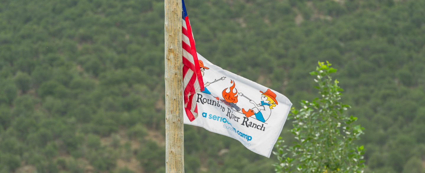 The American flag flies next to the flag of Roundup River Ranch, a Colorado nonprofit youth camp and youth summer program