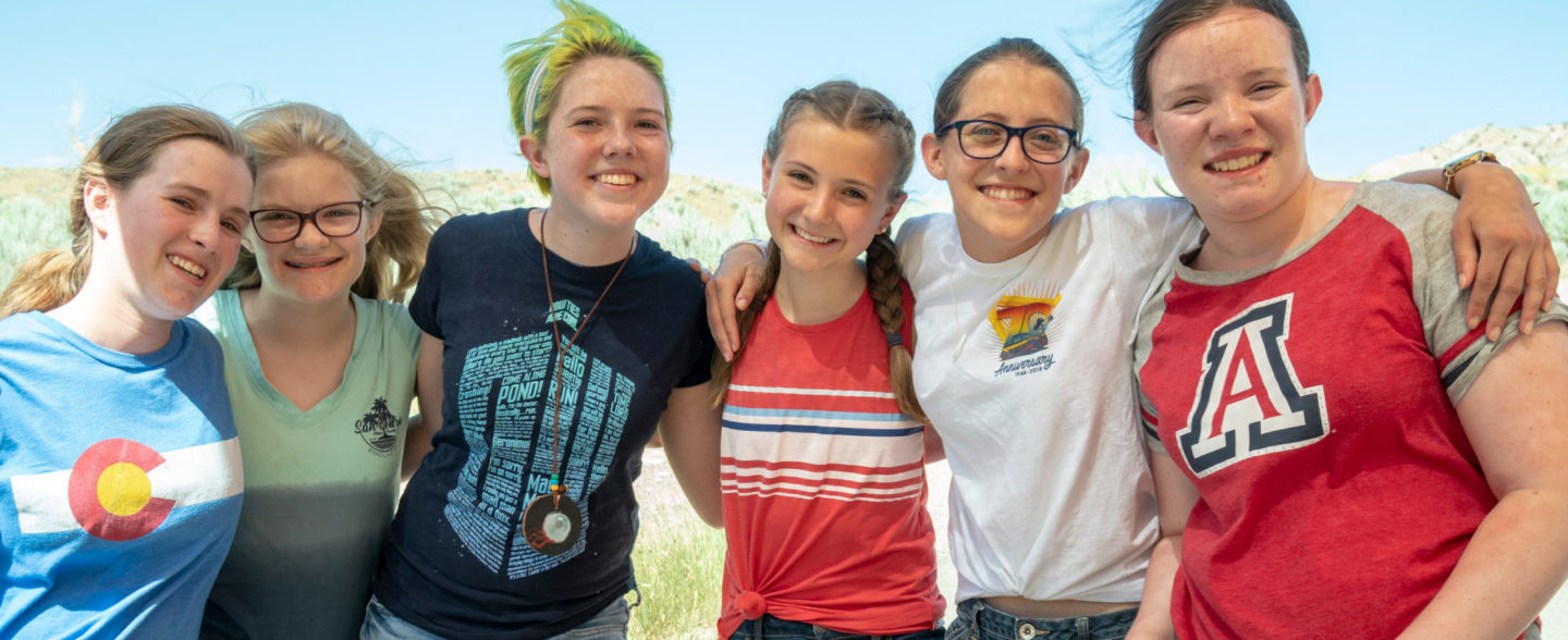 Volunteer camp counselor and children pose for a photo at Colorado nonprofit youth camp