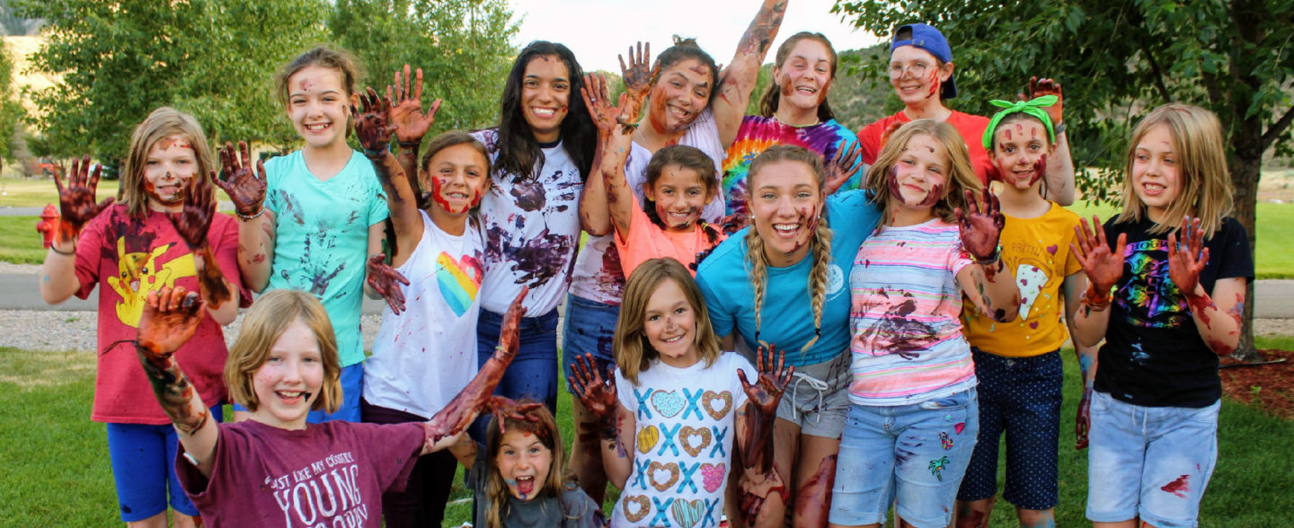 Happy children wave and smile while camping in Gypsum Colorado at nonprofit Colorado camp supported by children's charity donations